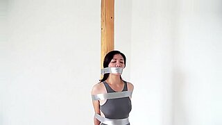Αποπνικτικός Κινέζος υποτακτικός δεμένος και πειραγμένος σε μια έντονη σκηνή BDSM.