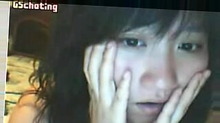 Una mujer asiática explora su coño apretado con su dedo pulgar en cámara.