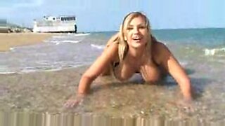 Gadis Eropah berpayudara besar, Carol Goldnerova, bermain dengan payudaranya di pantai telanjang.